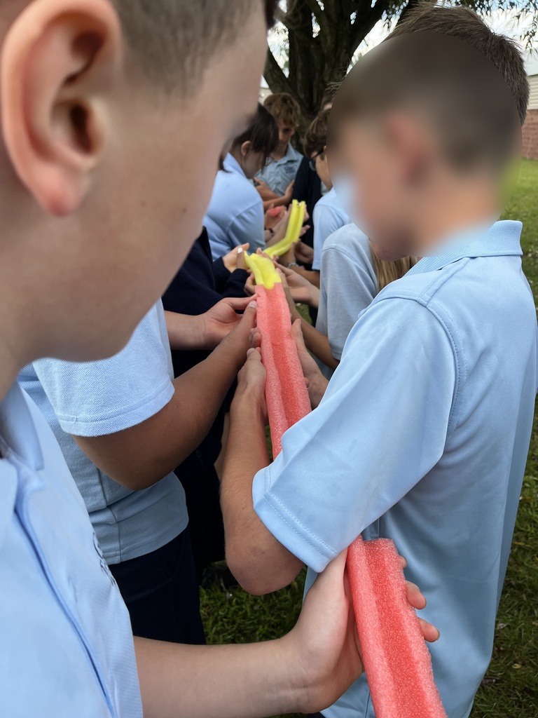 students holding pool noodle