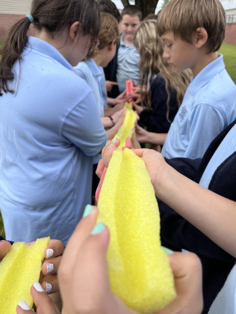 students holding pool noodle