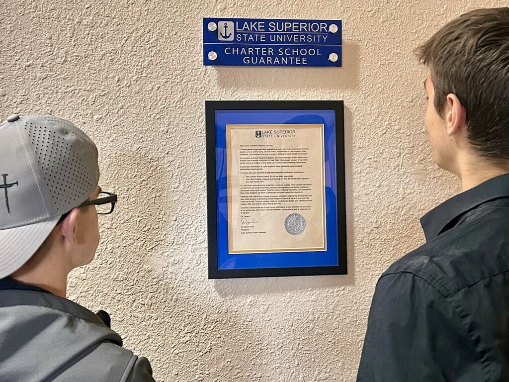 boys looking at certificate on wall