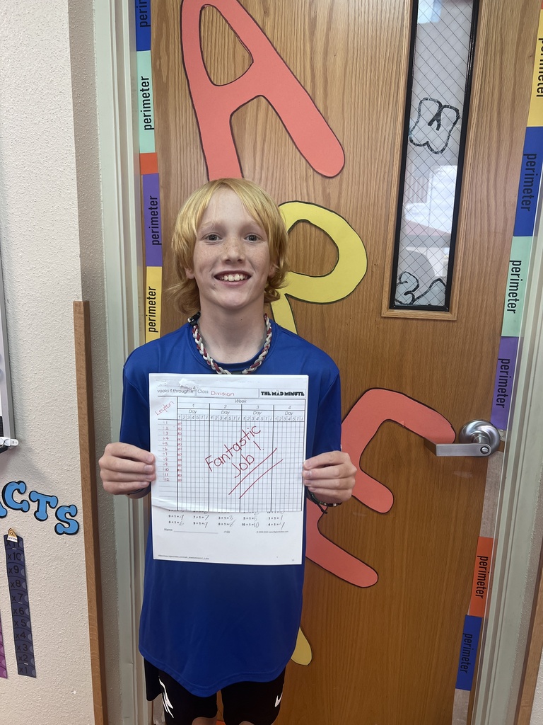 Student stands with work. 