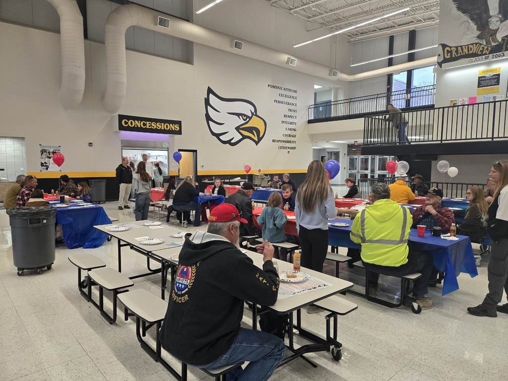 picture of family members and Veterans having breakfast in the high school commons