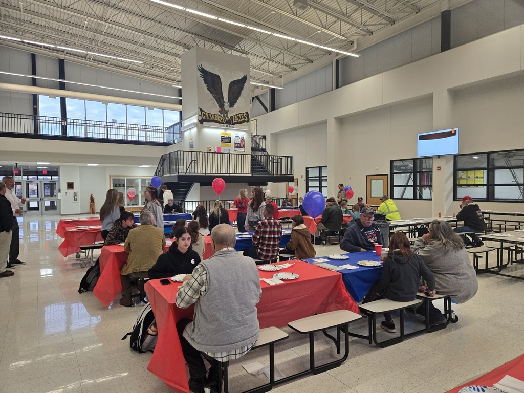 picture of family members and Veterans having breakfast in the high school commons