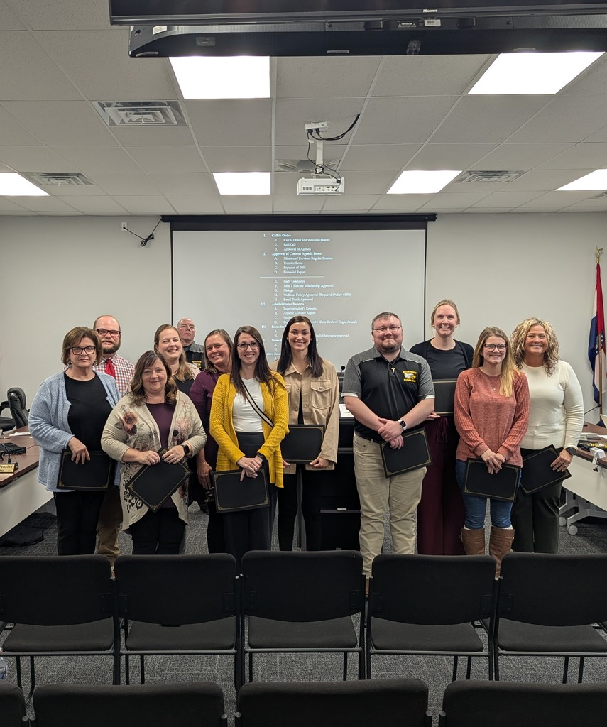 Group of teachers in a meeting room recieving an award