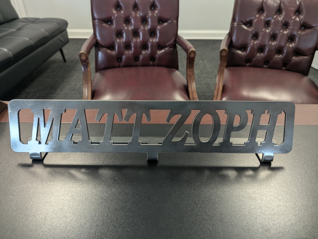 metal sign on a desk saying Matt Zoph.