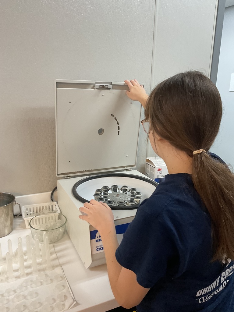 Student taking fecals out from the centrifuge.