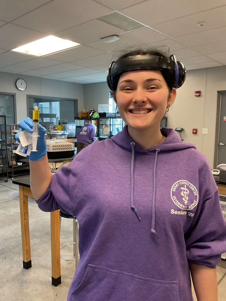student holding urine in a syringe