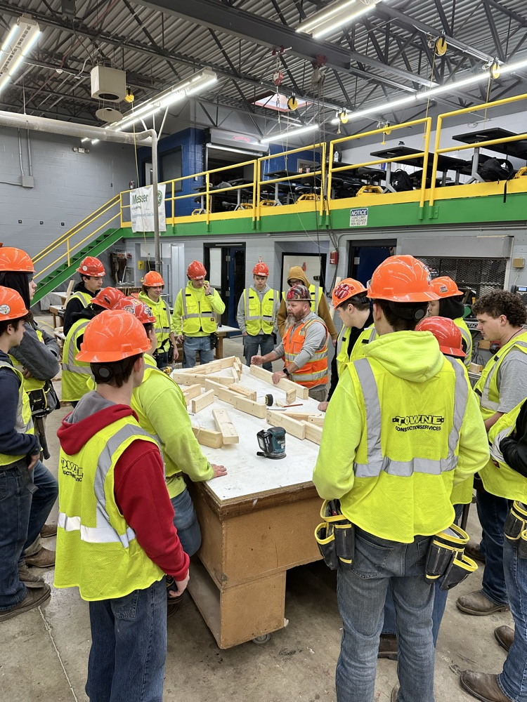 Kenny Carter demonstrates angle cuts on a mitre saw. Students utilize these skills in order to build their Christmas tree projects