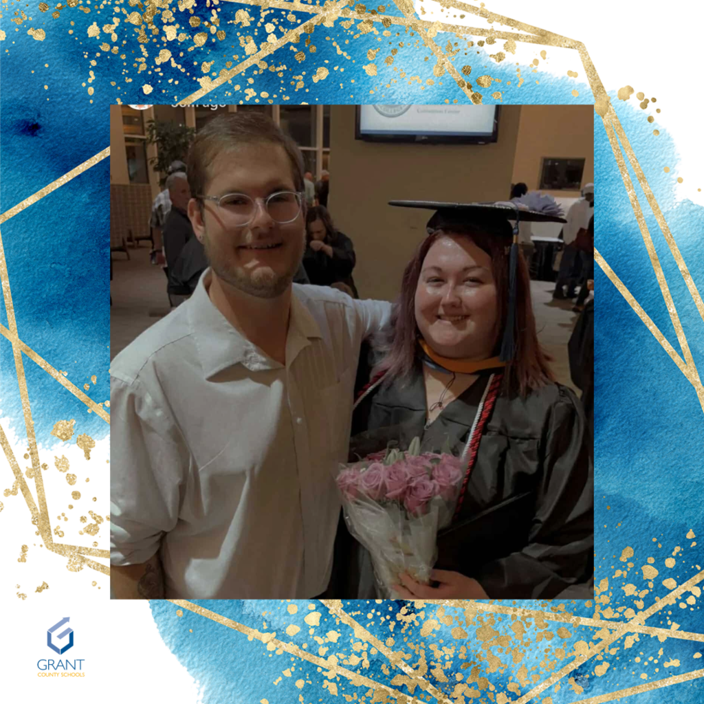 Man with glasses, woman in graduation cap with flowers