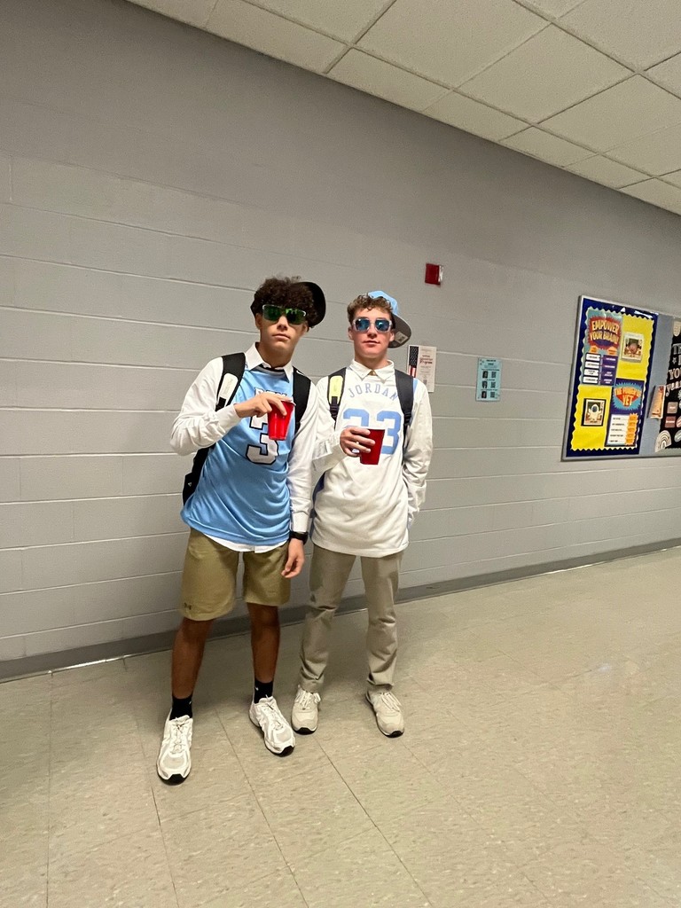 two boys in basketball jerseys and hats