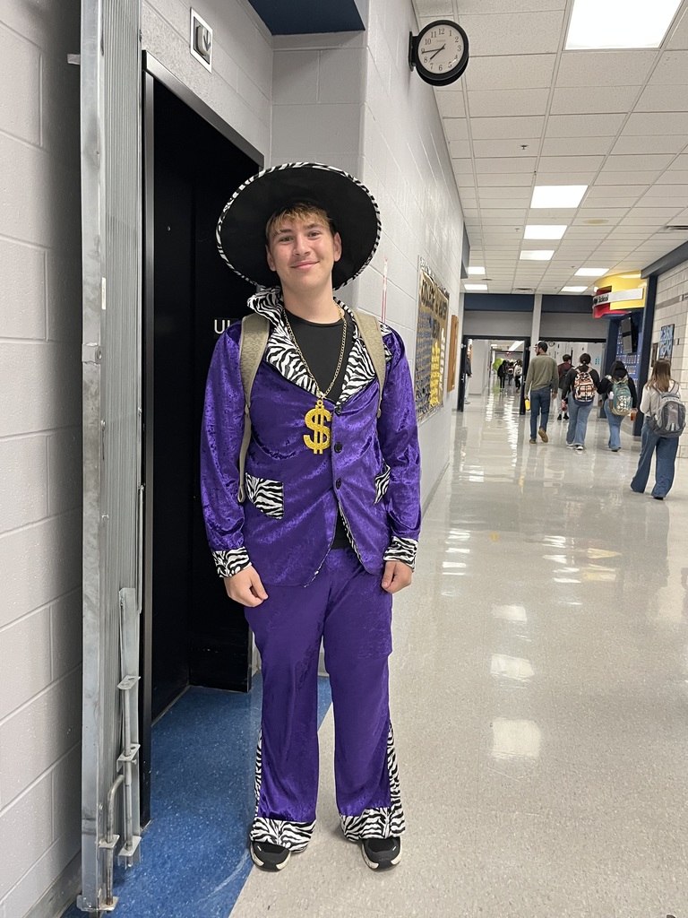boy dressed in purple with a hat