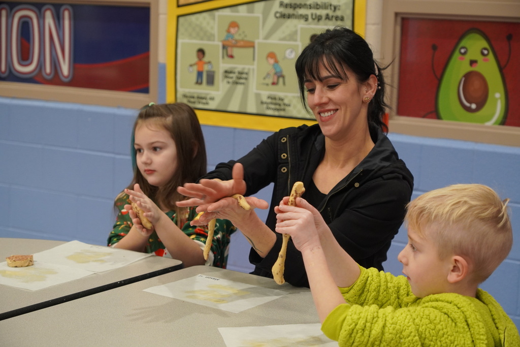 woman in black, boy in green, girl in christmas sweater