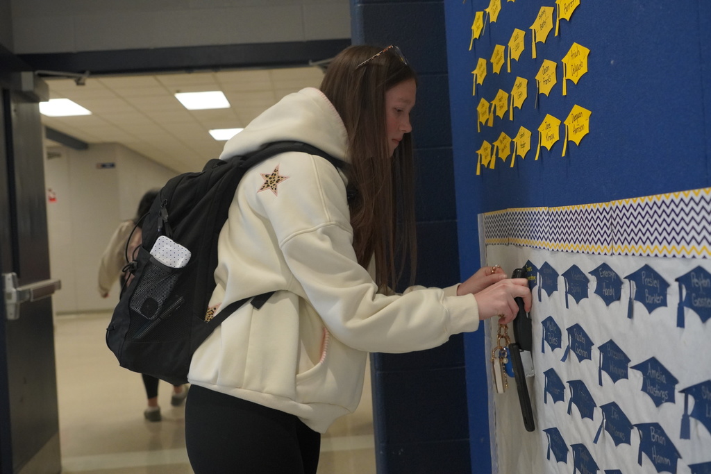 Girls staples her name on the wall