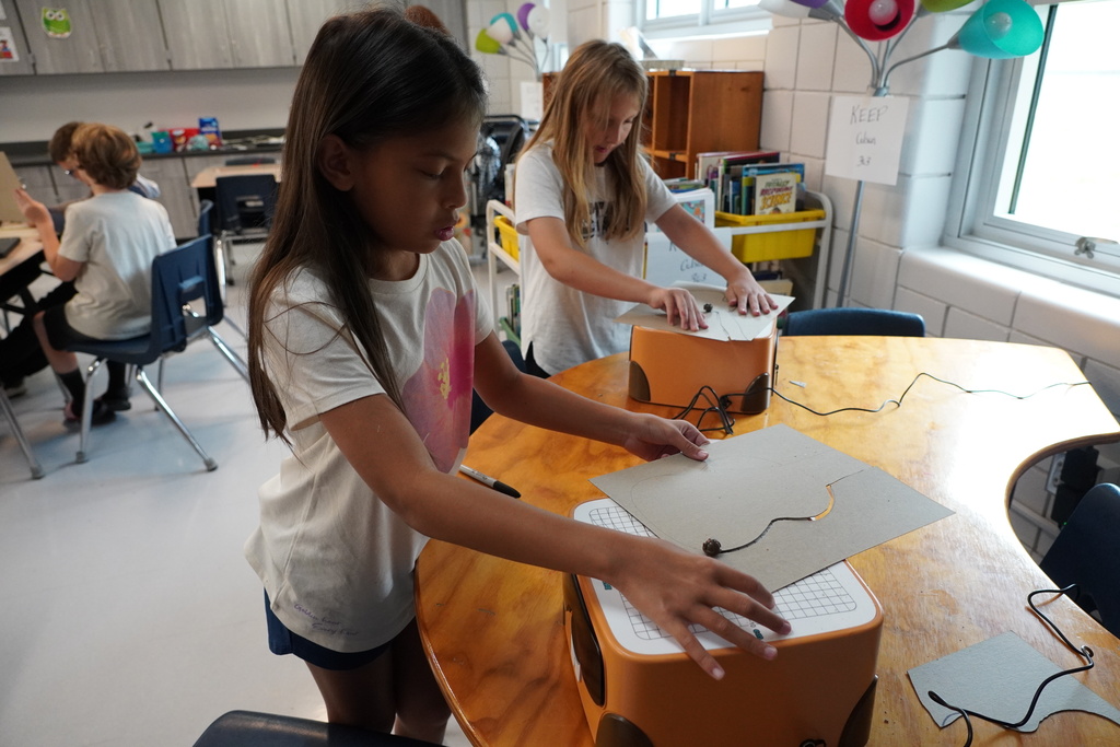 Student in white using a machine