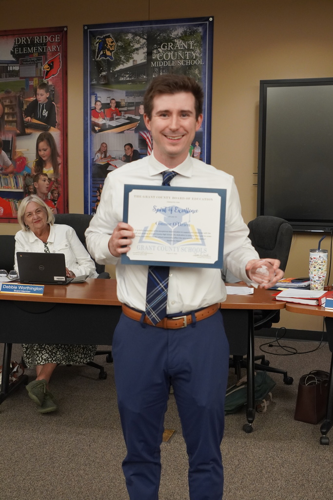 Male teacher smiling with a certificate