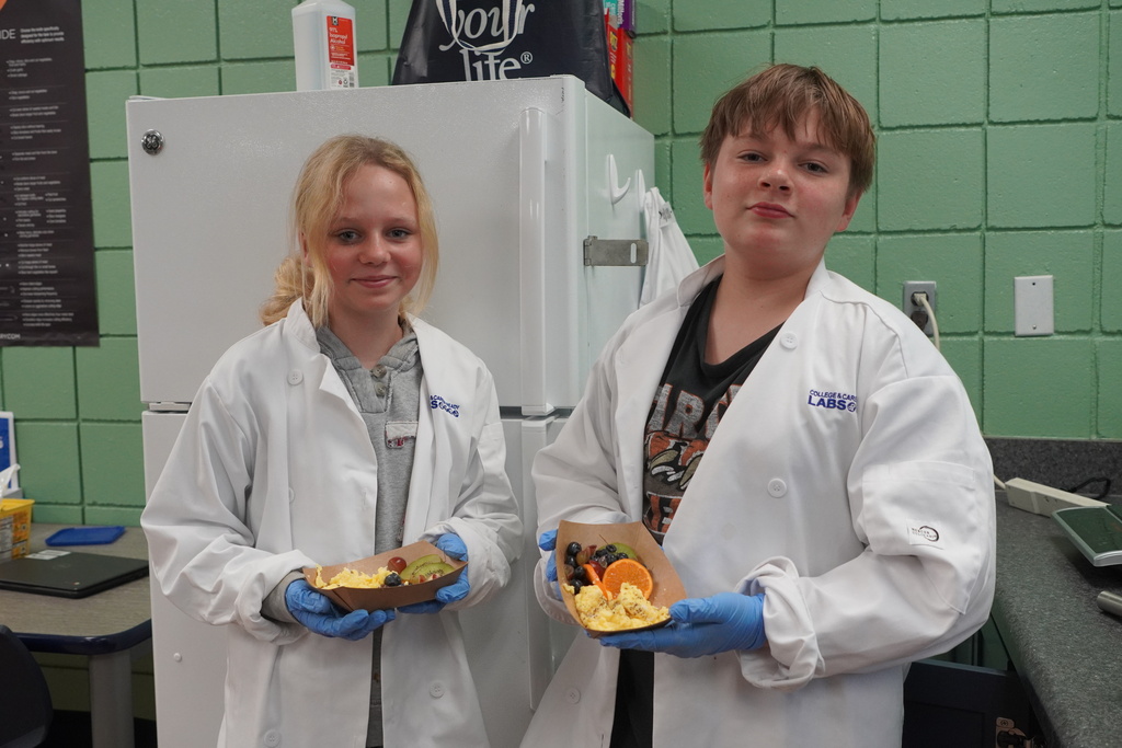 girl and boy smiling holding their food.