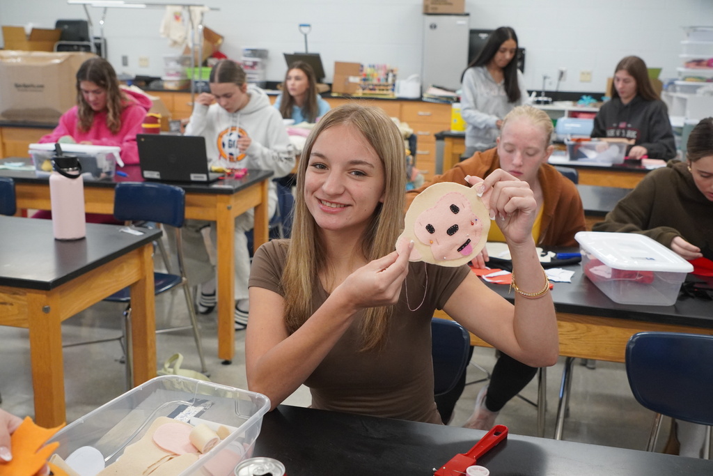young woman holding a stuffed animal pattern smiling