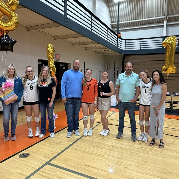 picture of Grant volleyball three seniors and their parents standing next to each other on senior night. from left to right: Lilian gee, Chloe mcgowen and Lillian Bouwkamp