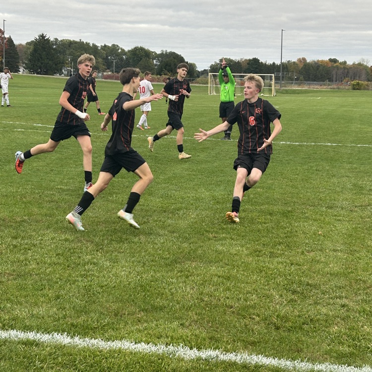 picture of four Grant soccer players celebrating after a goal was scored