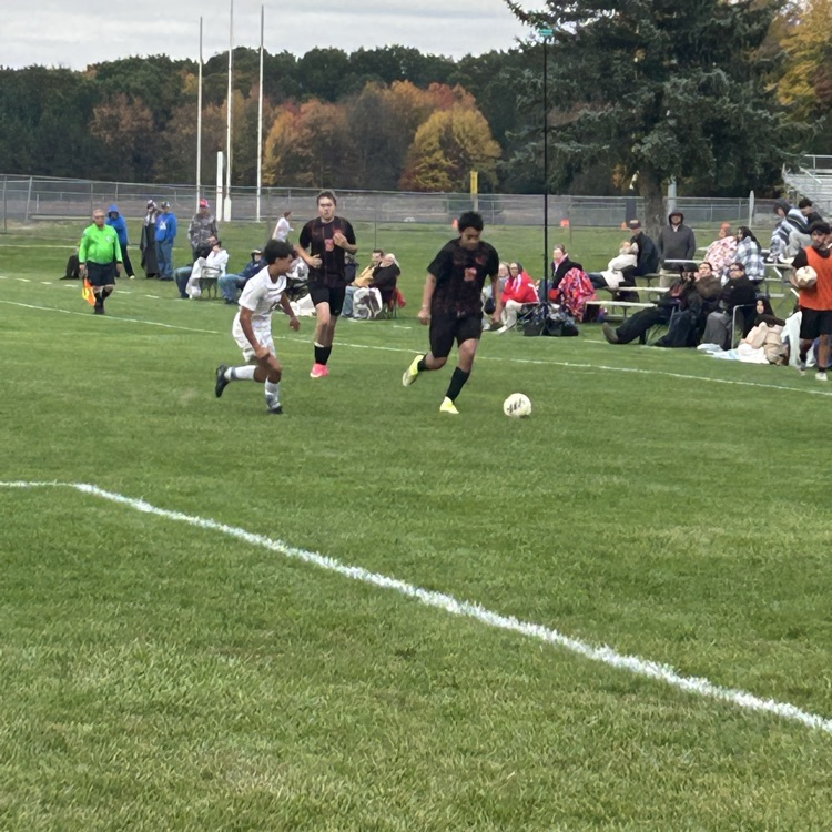 picture of a Grant soccer player dribbling the ball away from a chip hills player