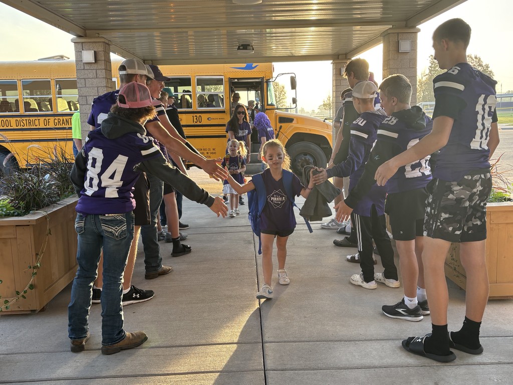 Football players greeting Elementary students.