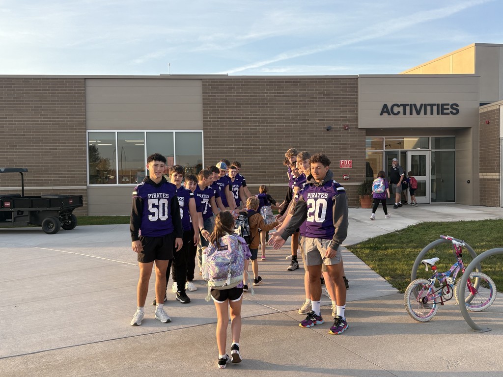 Football players greeting Elementary students.