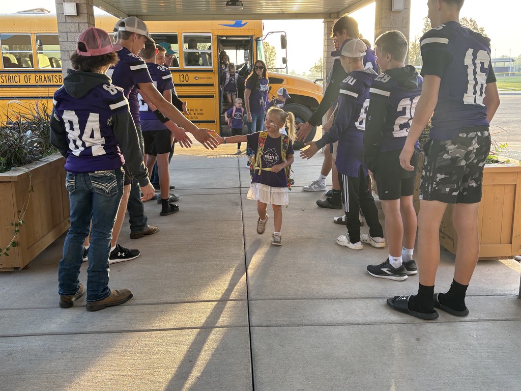 Football players greeting Elementary students.