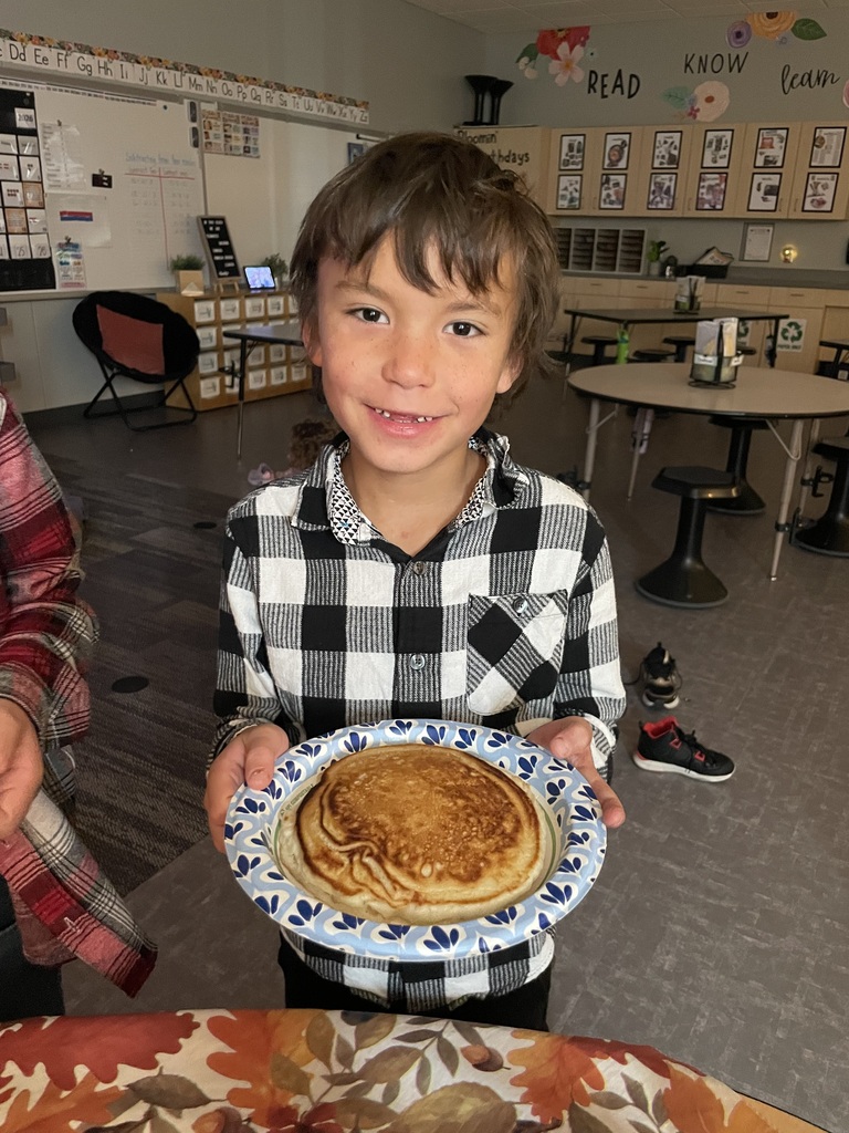 A student smiles in their flannel with colossal pancakes!