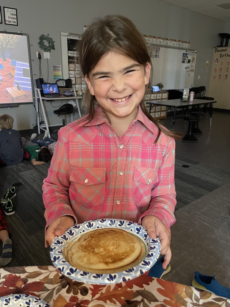 A student smiles wide with their big pancakes.
