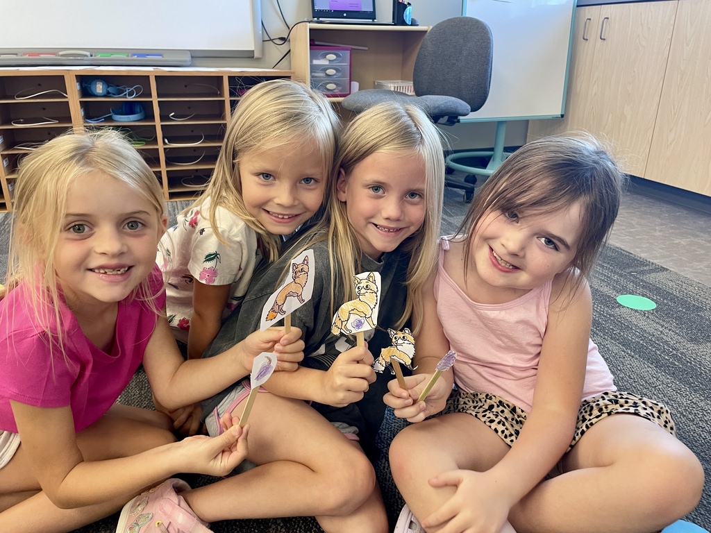 A group of students show off their stick puppets.