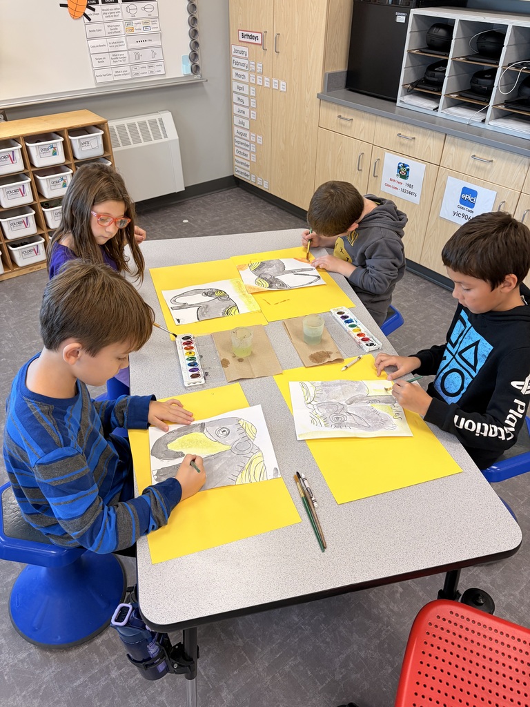 A group of students works hard painting their Asian elephants.