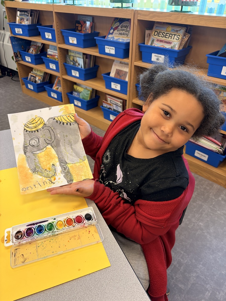 A student shows off their painted elephant.