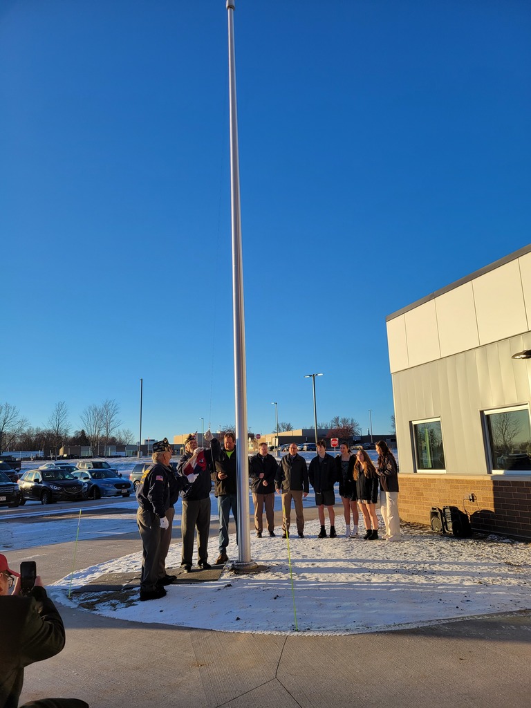 Members of the Grantsburg American Legion prepare to raise the flag