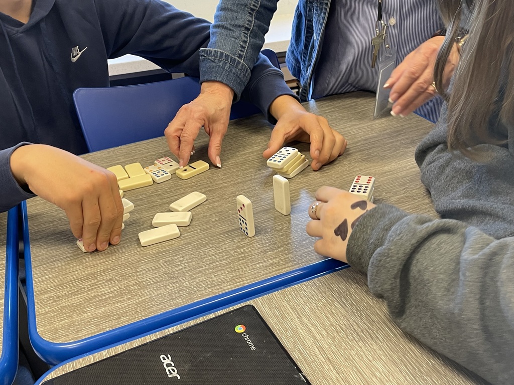 teacher and students working on domino challenge