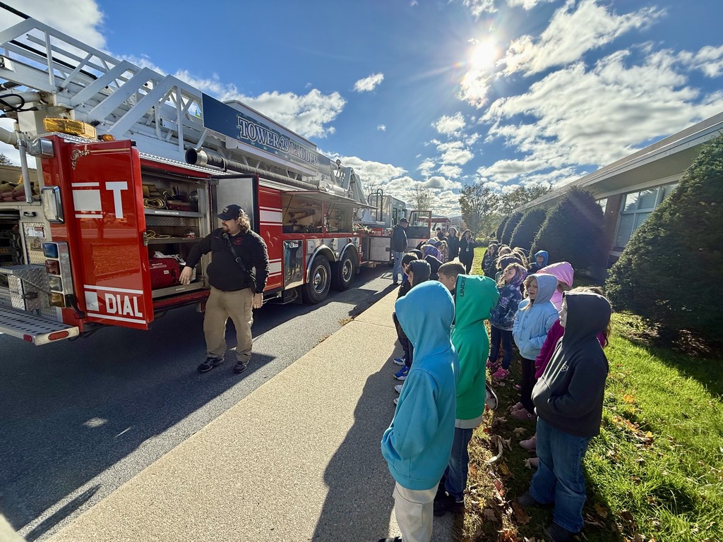 Fire Safety Lesson at MJT - students watch firefighter explain how a fire truck works