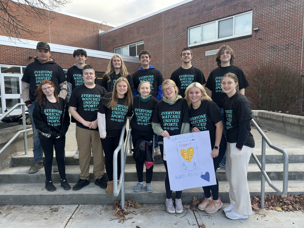 Everyone watches unified sports! A group of Jr/Sr High students wearing a black shirt with this writing