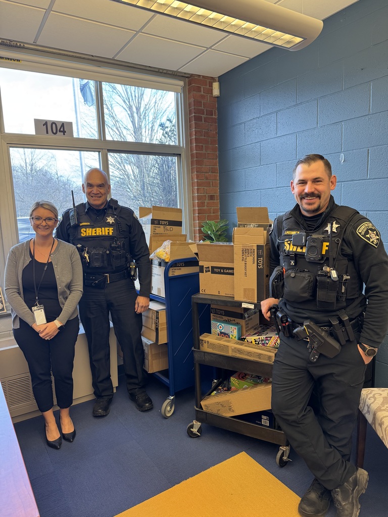 Two Washington County Sheriff Officers with boxes of toys and food for MJT families