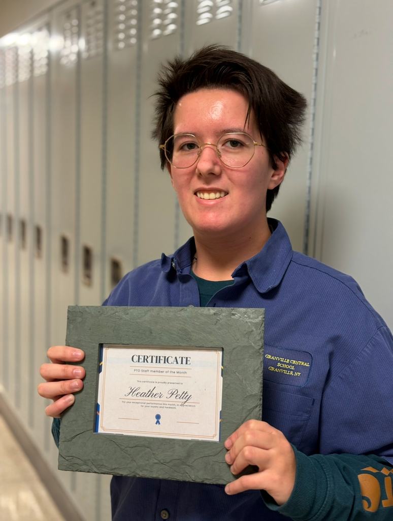 Ms. Petty standing in front of a row of lockers with the PTO gift 