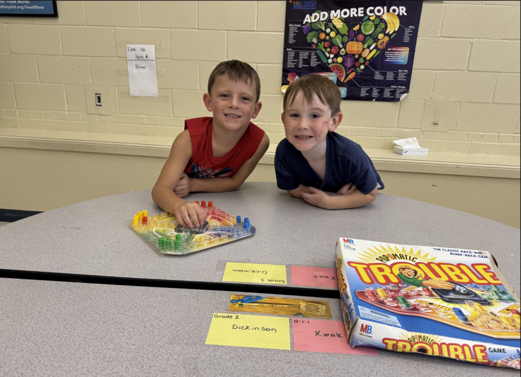 Two little boys play the game called Trouble in the MJT afterschool program