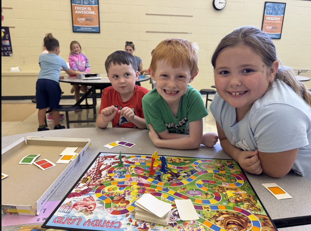 Three children play Candyland, in the MJT afterschool program