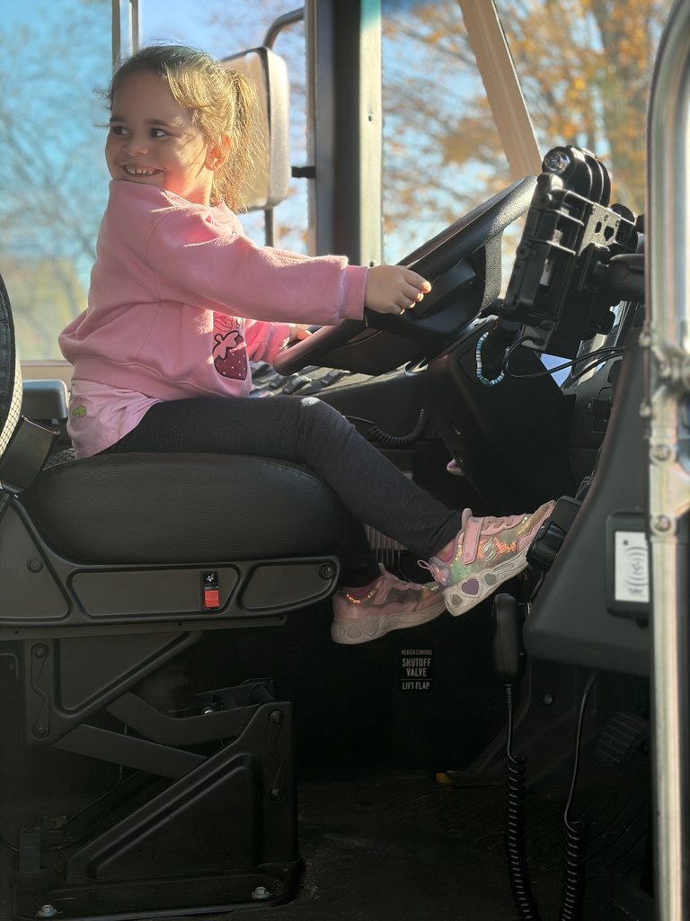 An MJT student pretends to drive the bus while experiencing what a noisy bus ride can be distracting