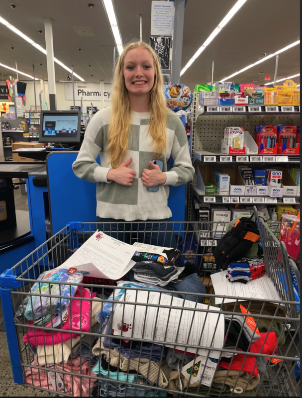 A picture of a student shopper and shopping items she and other shopper shared a cart.