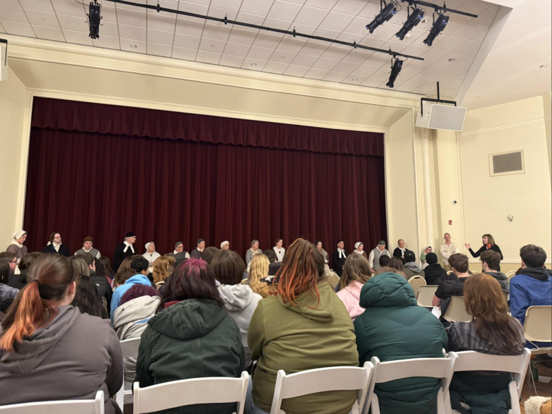 Students seated at the Saratoga Music Hall  as Ms. Sumo leads an overview of the play.