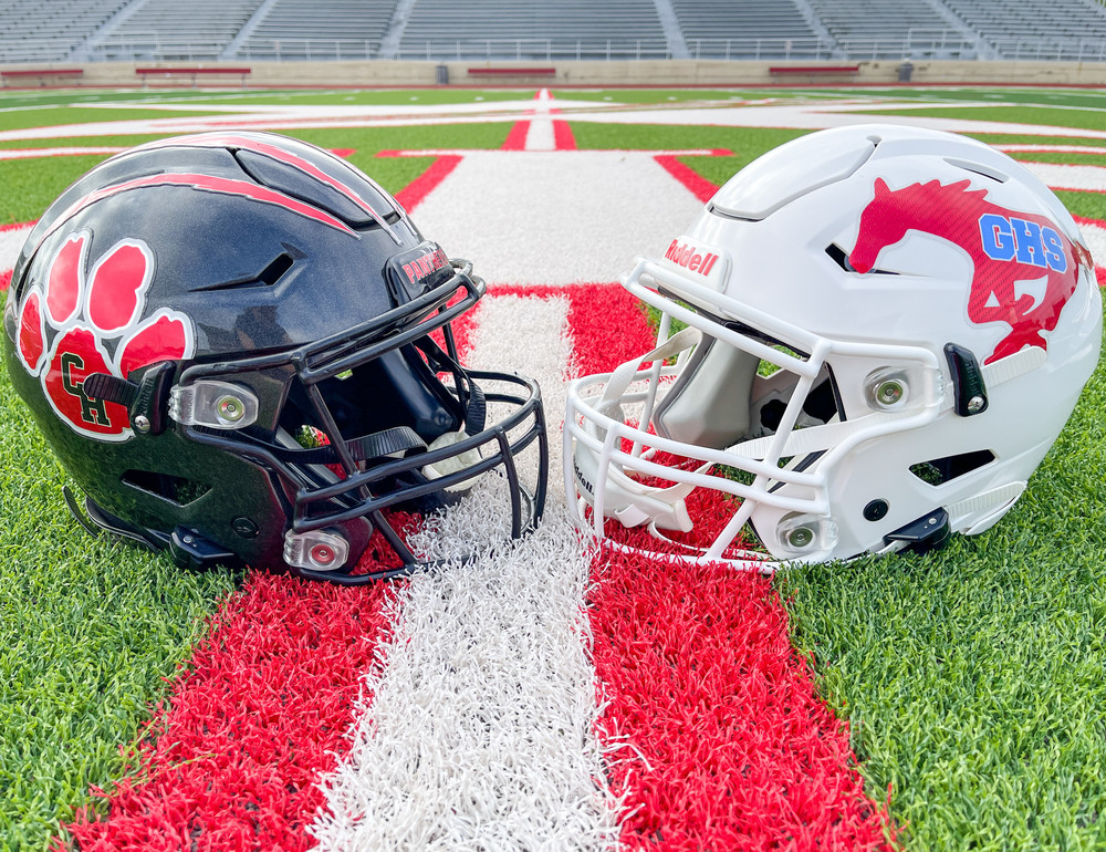 Colleyville Heritage and Grapvine High School football helmets lying on the ground facing each other