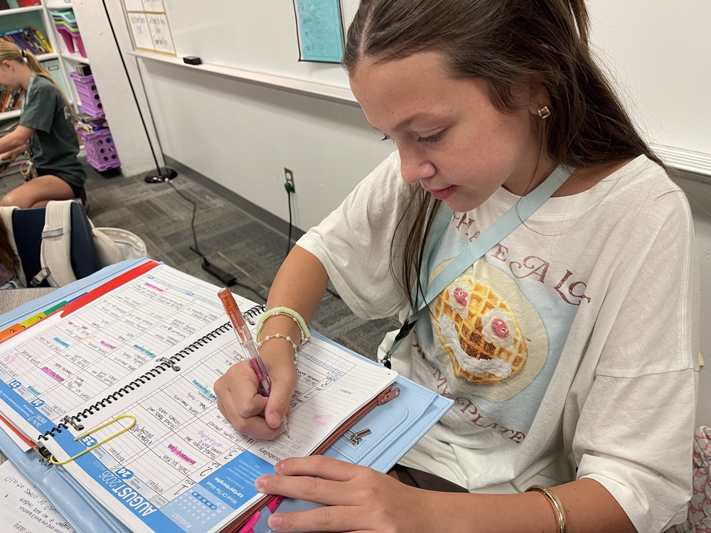 Student writing in her planner