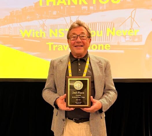 Bus driver holds award plaque