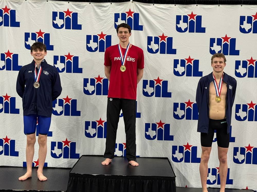Aiden Tokarski posing on the State Championship podium with his medal