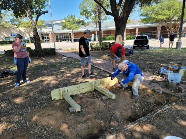 People working on flower beds in front of Heritage Middle School.