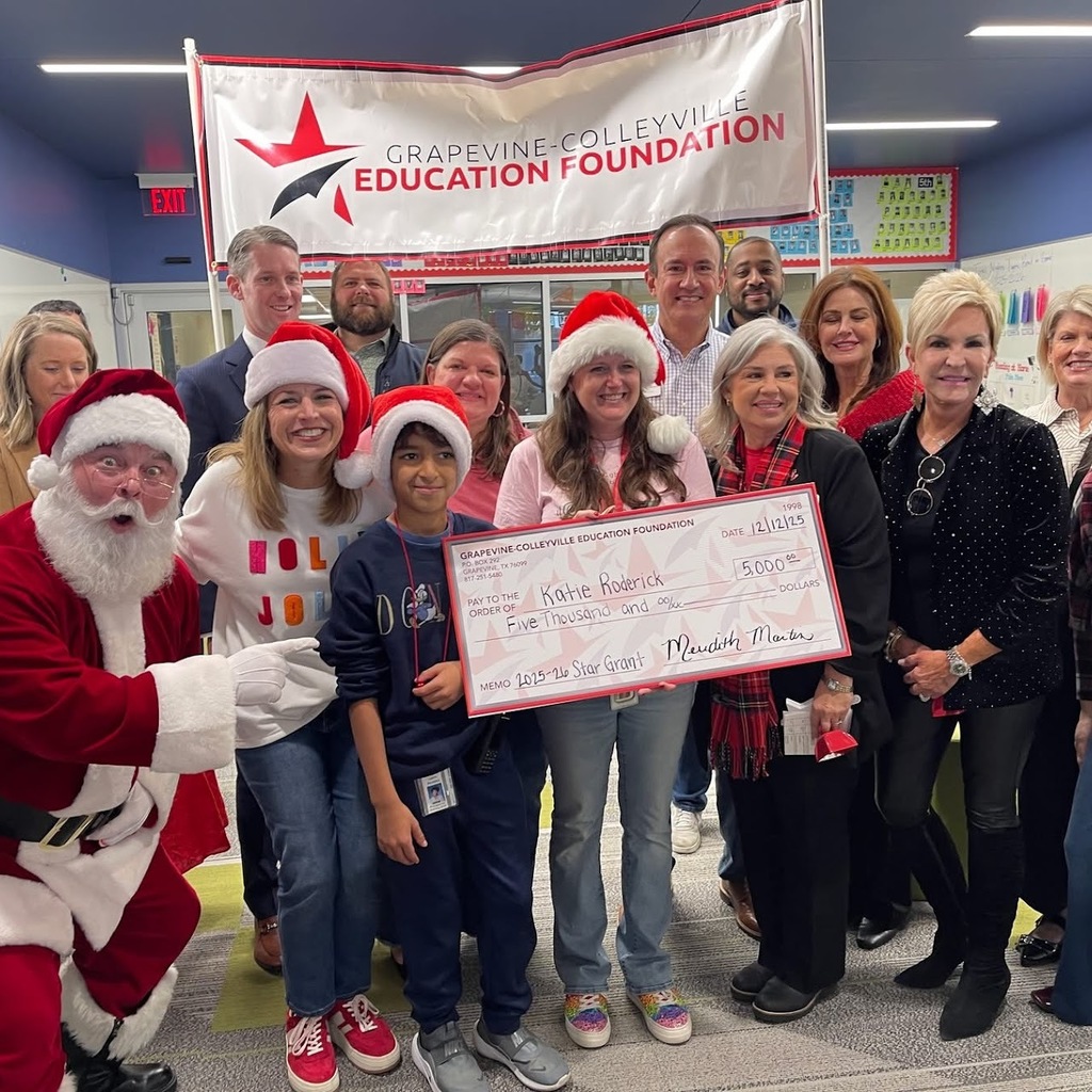 Santa and the grant committee presents an oversized check to a grant winner.