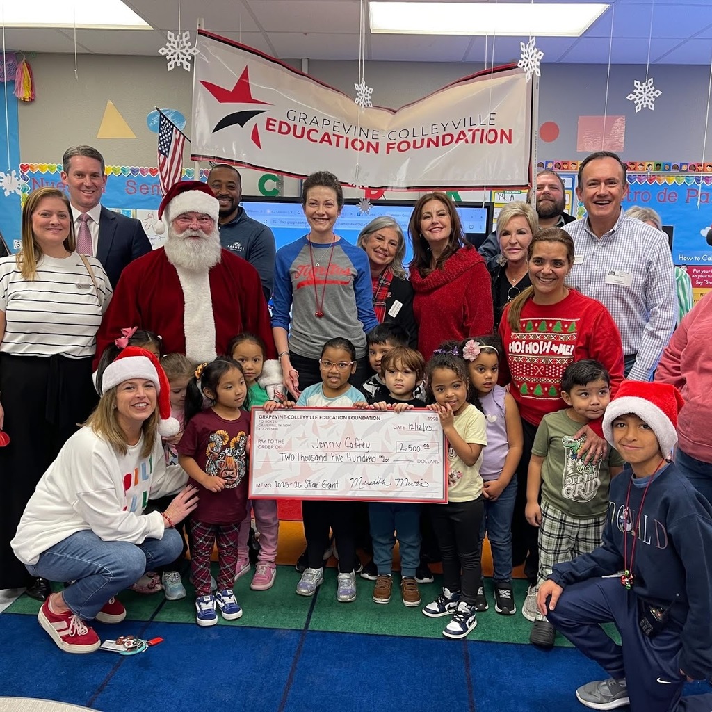 Santa and the grant committee presents an oversized check to a grant winner.