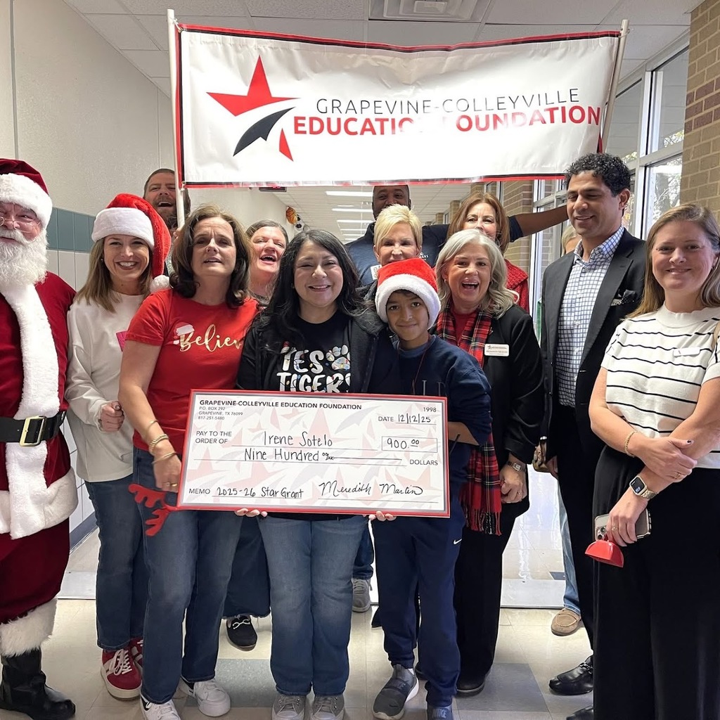 Santa and the grant committee presents an oversized check to a grant winner.